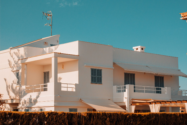 Hình ảnh tham khảo: mặt đứng nhà màu trắng với ban công và nền trời xanh